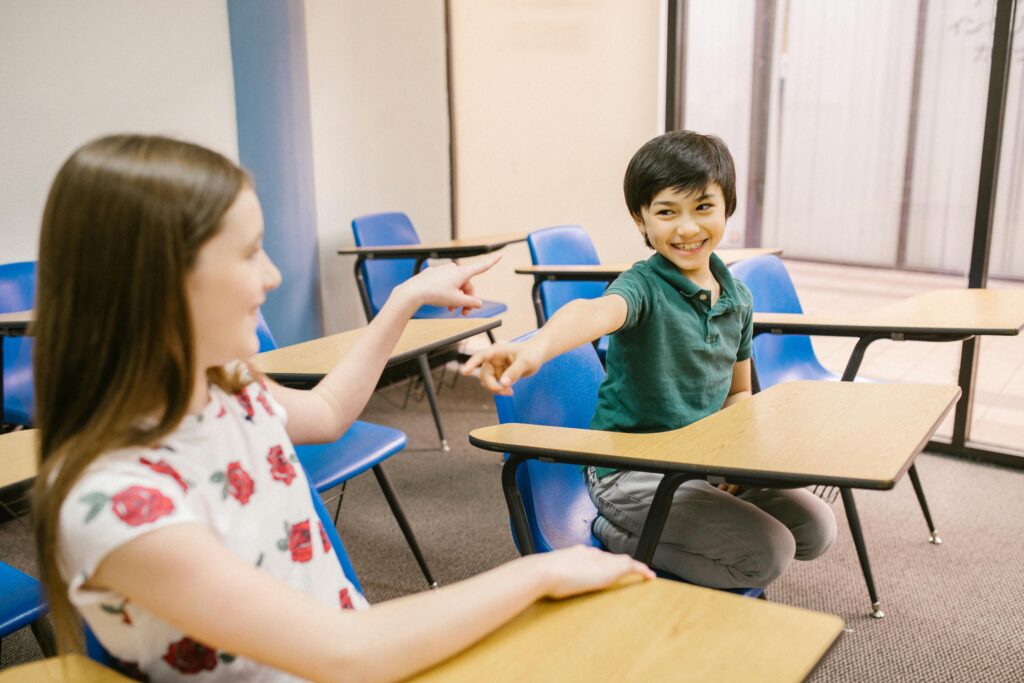 Children interacting and smiling in an educational classroom environment.